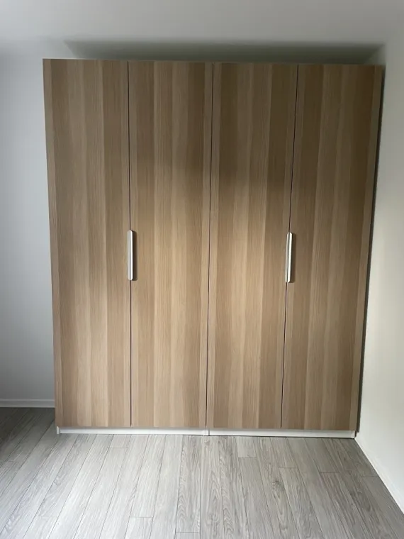 Porte effet bois avec poignées blanches assez discret.